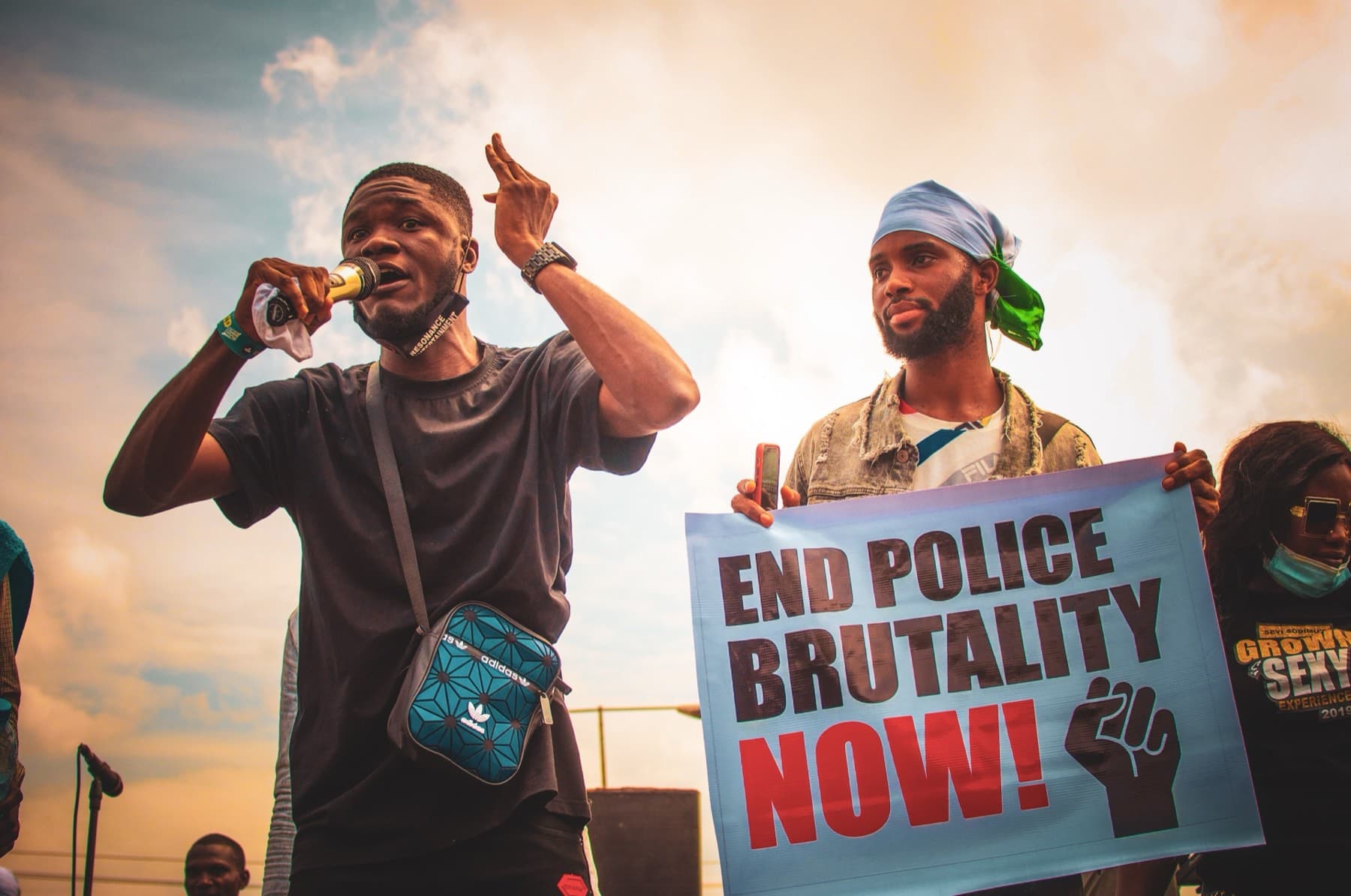 Protesters at an #EndSARS demonstration in Abeokuta in October 2020, one holding a placard reading End Police Brutality Now.